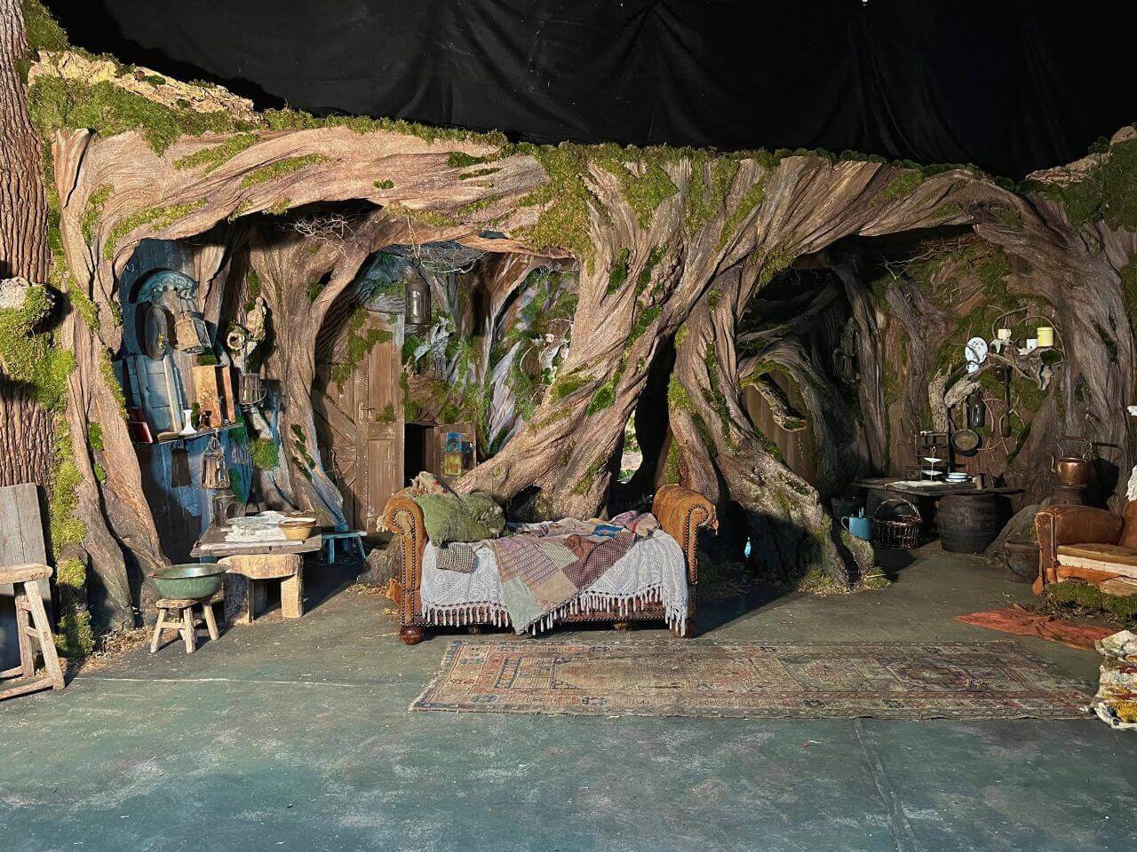 Red Riding Hood Wolfs Lair - Brian Sykes Designer Detailed view of Red Riding Hood wolf’s lair set with twisted tree walls and rustic furniture.