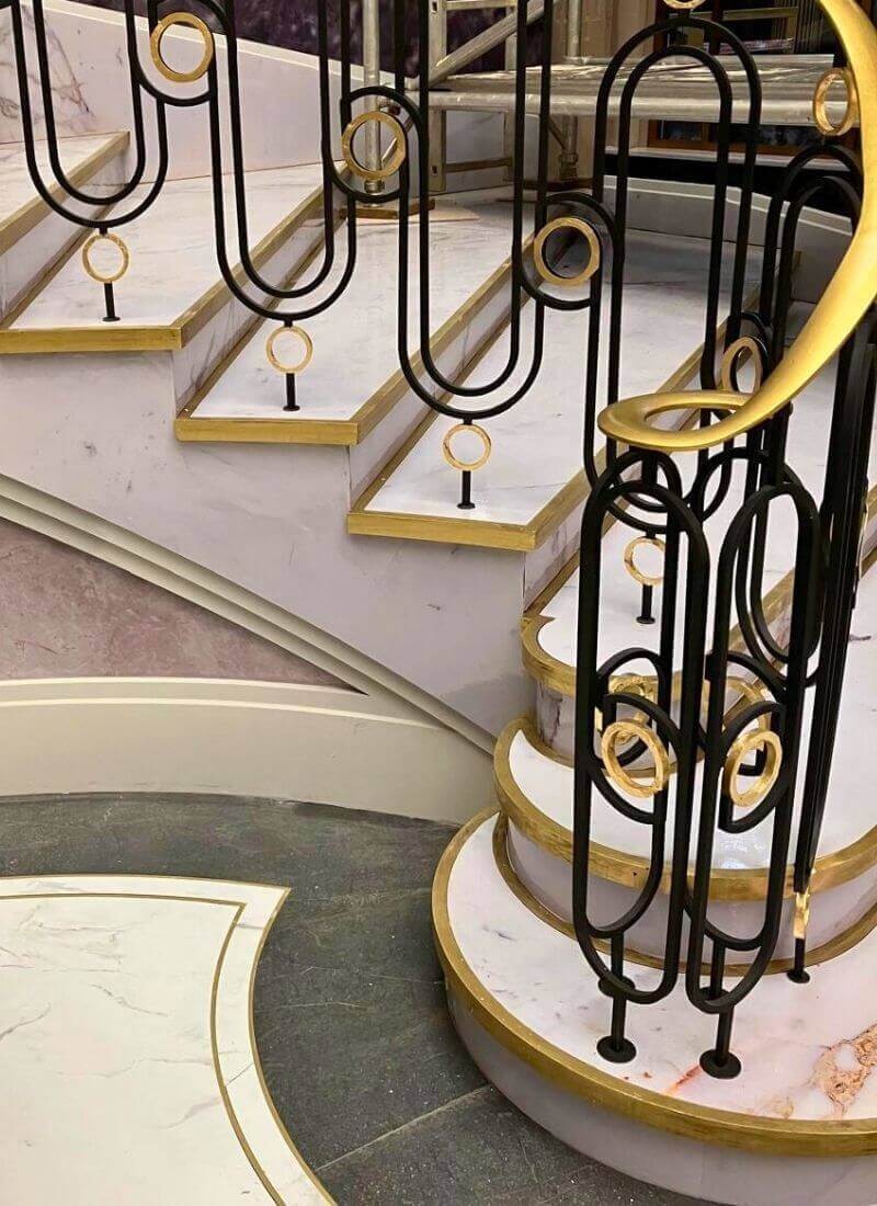 Man vs Baby - Staircase Gold Detailing – Scenic Metalwork Finish Close-up of staircase treads and balustrade showing painted gold trim and black metalwork on the penthouse set.