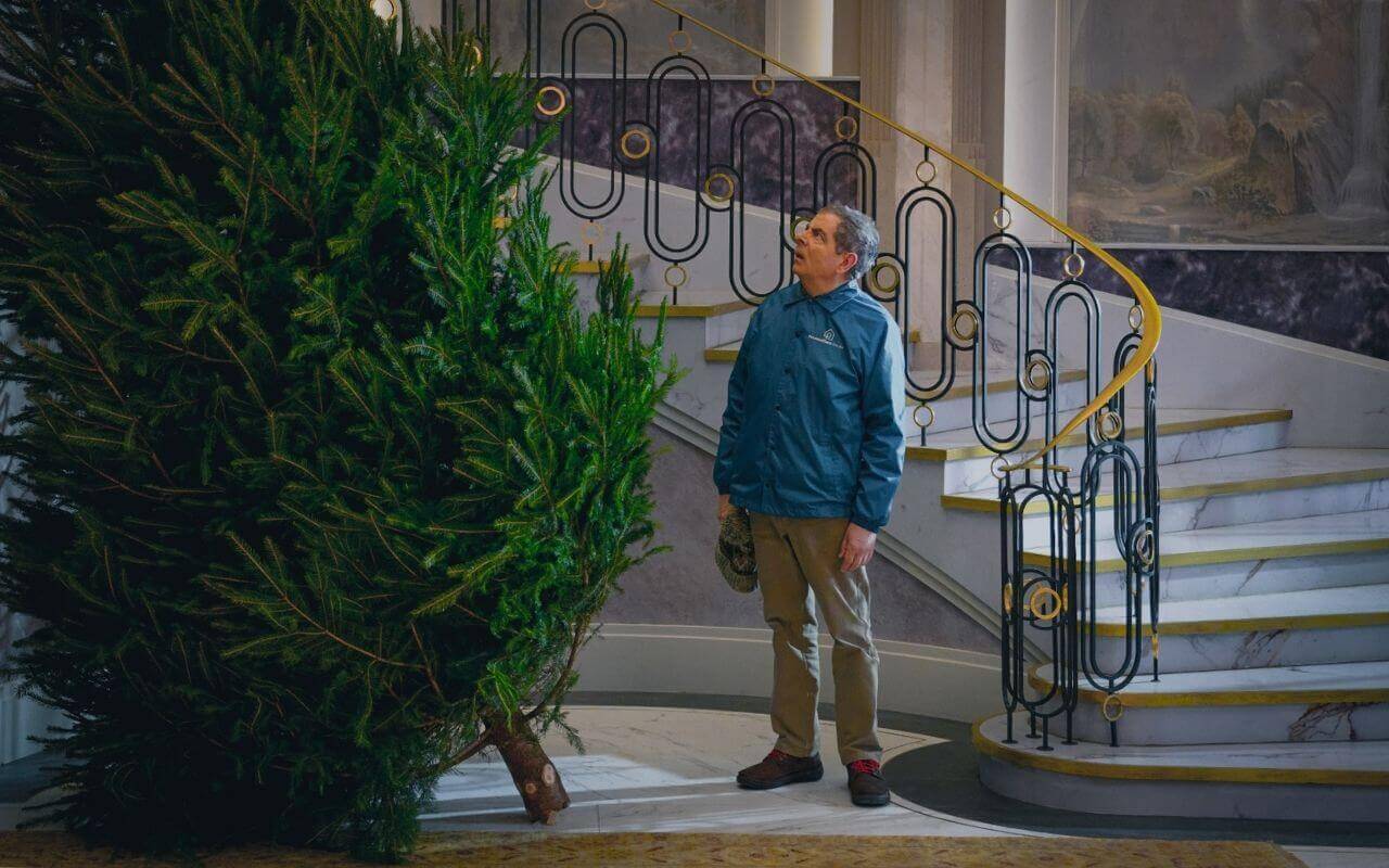 Man vs Baby - Staircase and Christmas Tree Large Christmas tree placed in the centre of the penthouse hall set, with curved staircase and scenic murals behind.