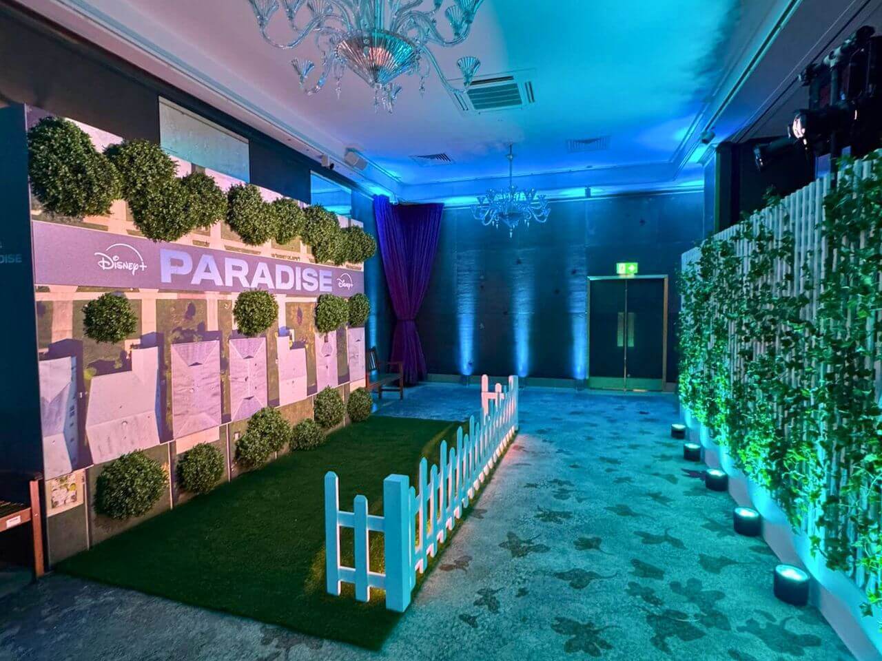 Paradise Launch Event – Immersive Event Environment Wide view of Paradise launch event showing scenic backdrop wall, garden set build and immersive environment within The May Fair Hotel.