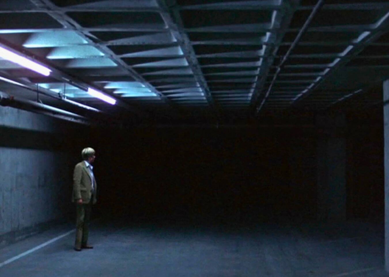 All the President’s Men Reference Film still showing a stark interior with a low concrete grid ceiling used as visual inspiration for a later set design.