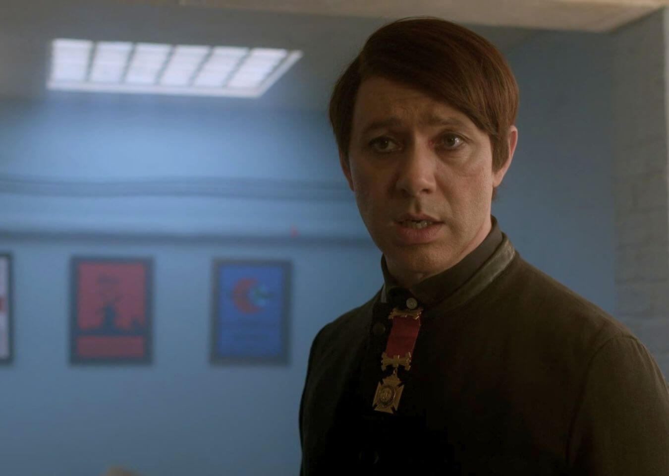 The Understudy On Screen Scene still from Inside No. 9: The Understudy showing a character in a dim basement-like room with glass bricks overhead casting light from above.